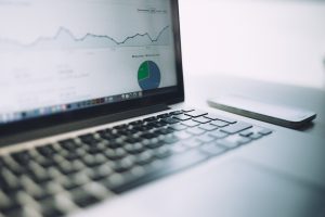 A laptop with charts and graphs on the screen