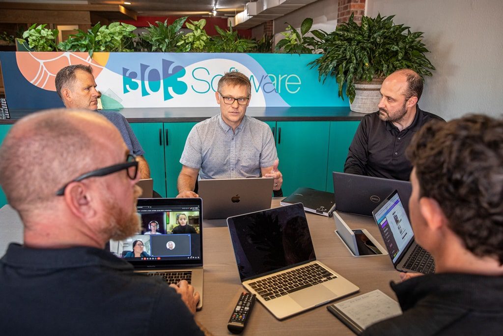 app development company Denver based 303 software sits down with clients for a meeting.