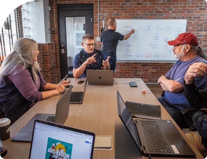 A team of focused app developers strategizing in a boardroom in Denver, Colorado.